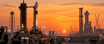 Illustration of rockets beside launch towers and cranes at a coastal launch complex at sunset.