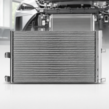 A silver metallic automotive radiator shown from the front, with a blurred background of a car engine bay.