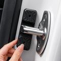 A close-up of a hand installing a black magnetic door stopper with a silver metal handle onto a white car door.
