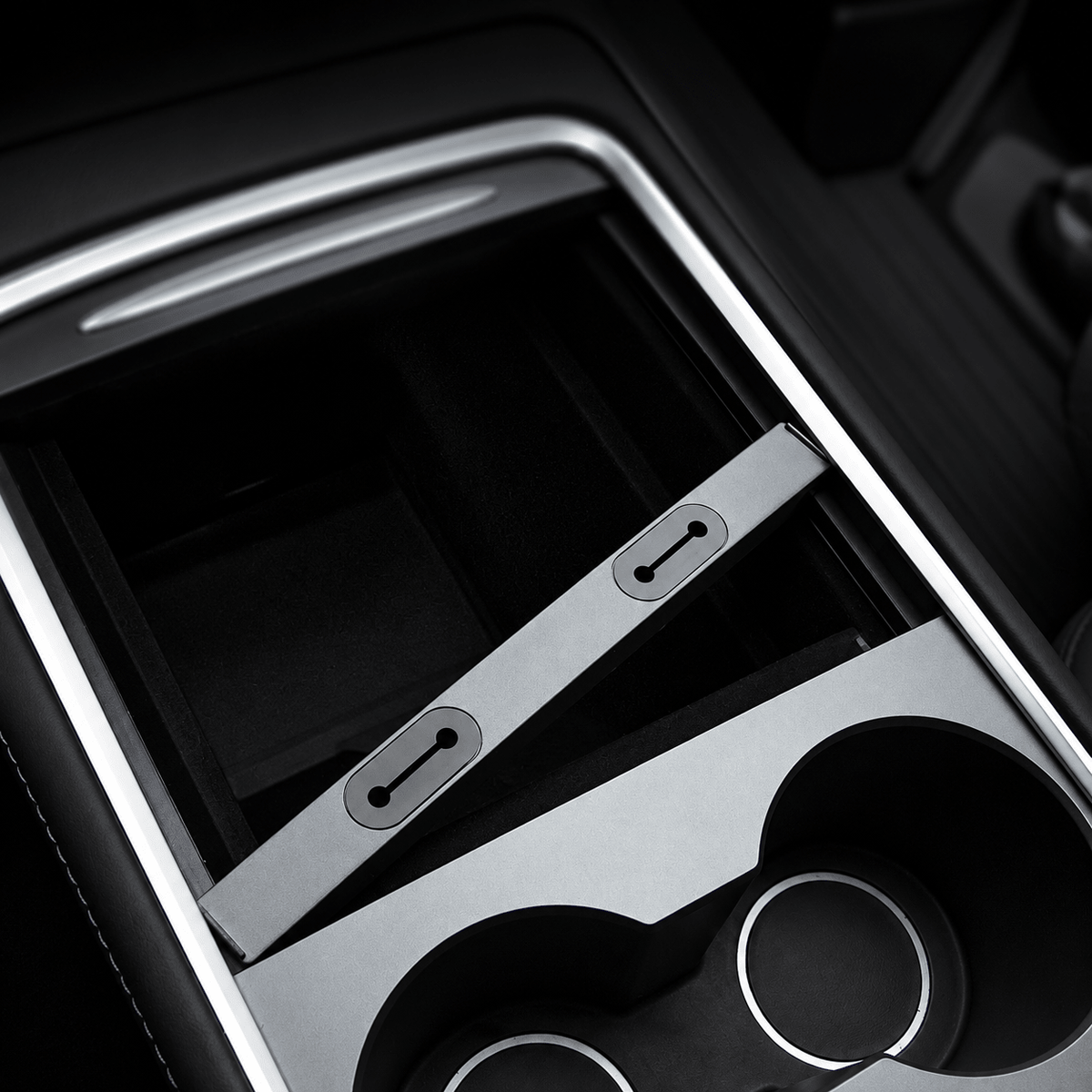 Center-console storage opening and cable-routing slots beside the cupholders.