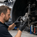 Mechanic holding a hub assembly against an exposed wheel mounting area with the wheel removed.