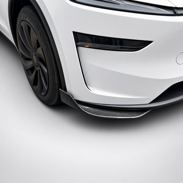 Carbon-fiber lower bumper corner trim fitted near the front wheel of a white Model Y Juniper