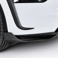 Close-up of carbon-fiber lower bumper corner trim beside the front tire