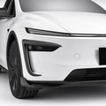 Angled front view of a white Model Y with carbon-fiber trim at the bumper corners
