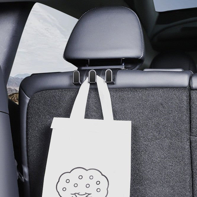 Black seatback hook plate with two upper mounting slots and three curved lower hooks.