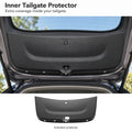 Black inner tailgate protector fitted to an open Tesla Model Y Juniper hatch, with the included leather-texture TPE protector below.