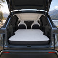 AI-assisted parked cabin with mattress, beige roof shade, and black privacy shades over front windshield, rear glass and side windows; vehicle not included